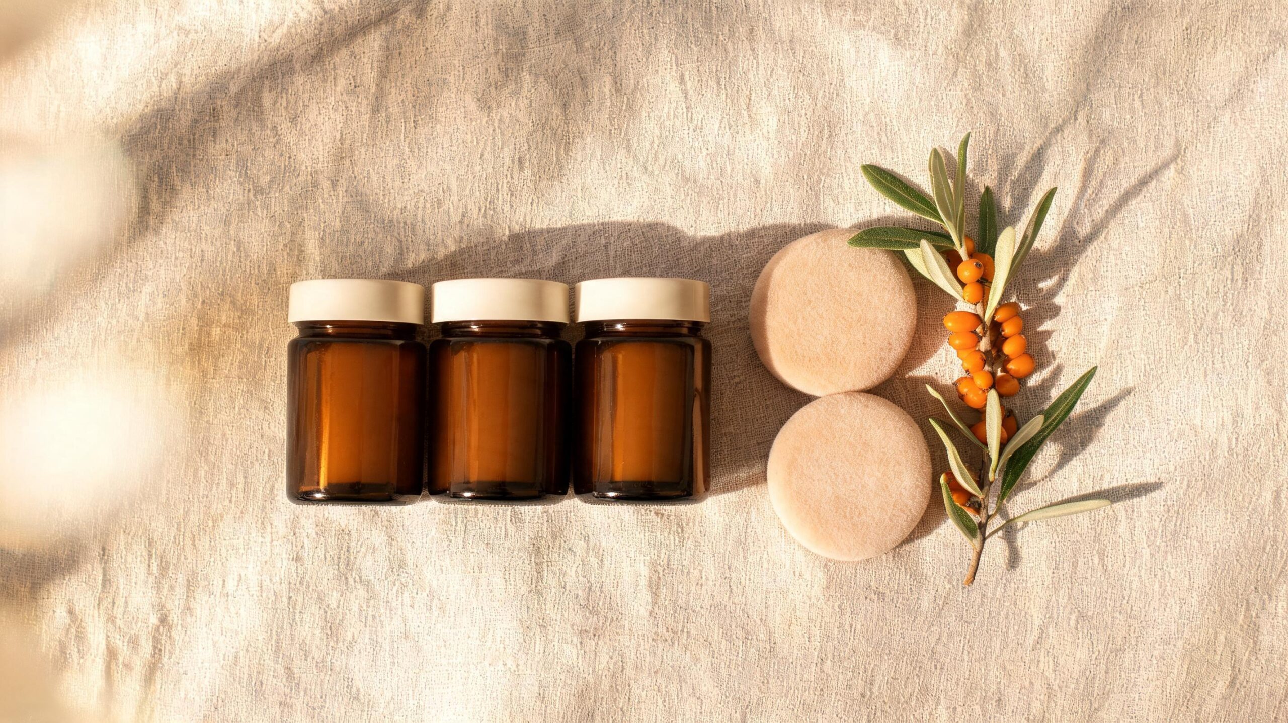 Collagen-tripeptide flatlay featuring supplement jars, sea buckthorn sprig and soft morning light